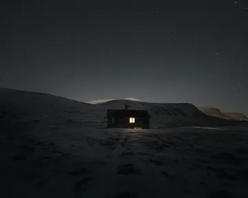 Luz de una casa en la negrura de la noche, representativa de la soledad y el avandono rural desde hace más de un siglo
